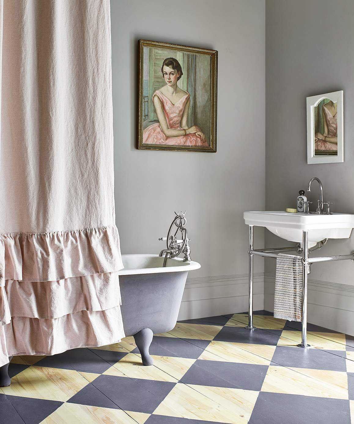A traditional-style bathroom with checkerboard painted wooden flooring and a freestanding bath with a shower curtain