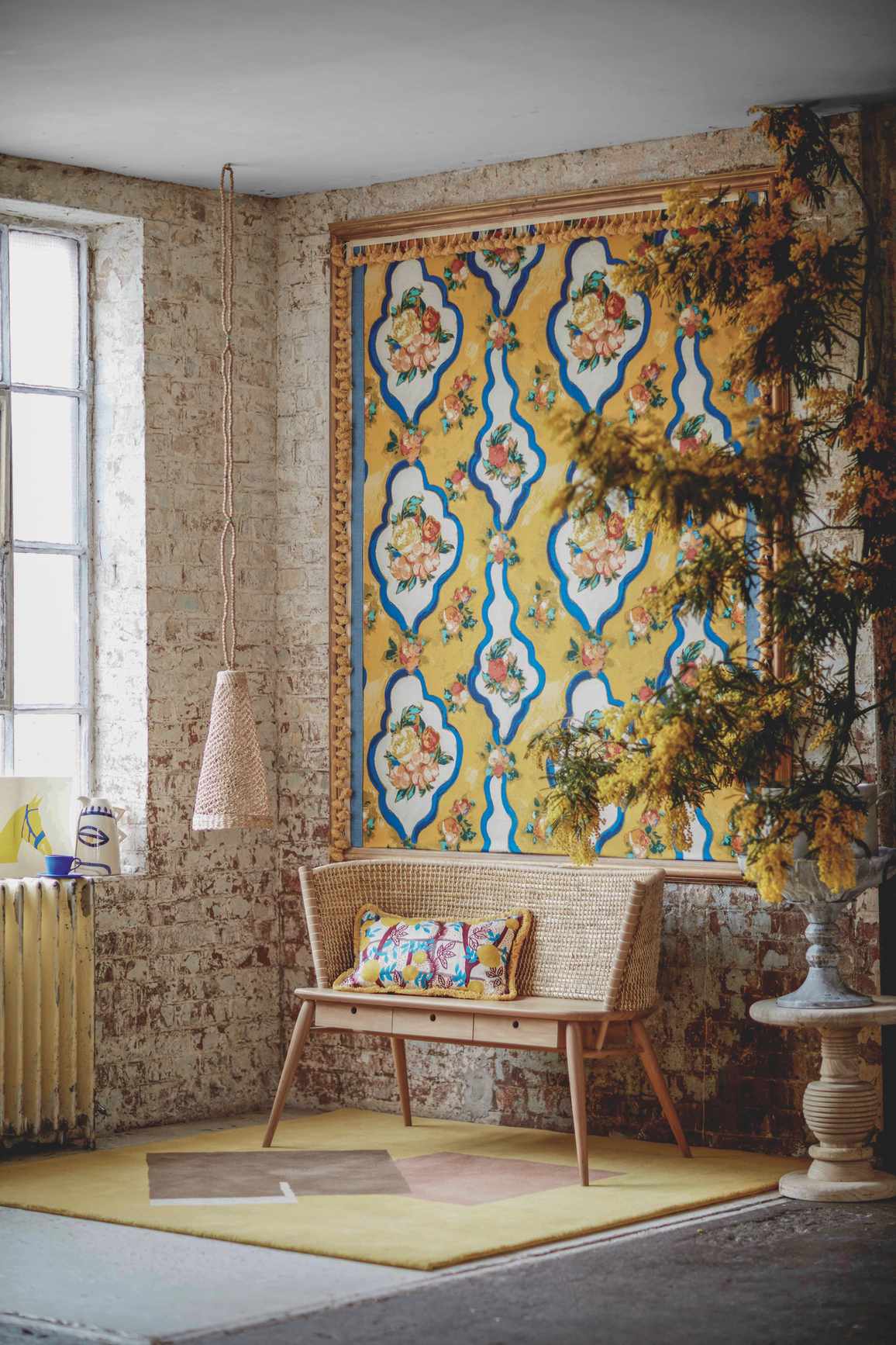 exposed brick wall with yellow hanging, wooden bench and low hanging pendant