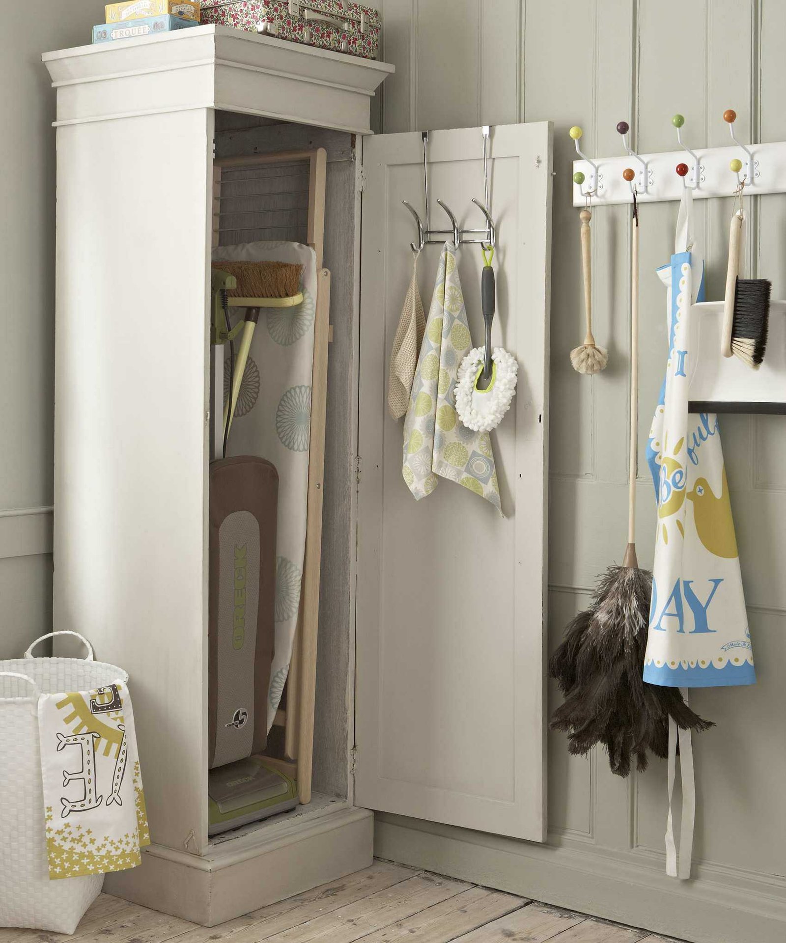 A laundry room with tall beige cabinet housing an ironing board