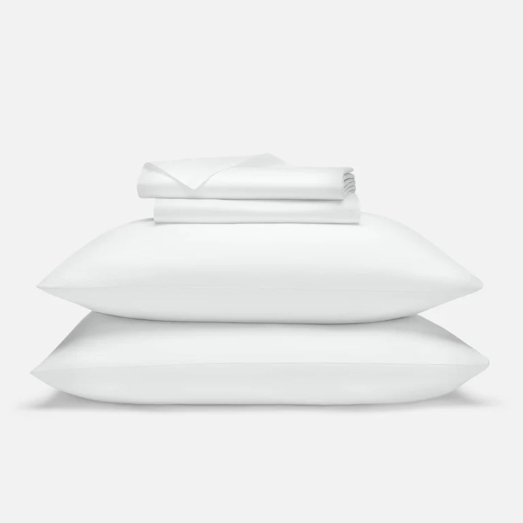 White Brooklinen Luxe Sateen Core Sheet Set shown folded and piled up