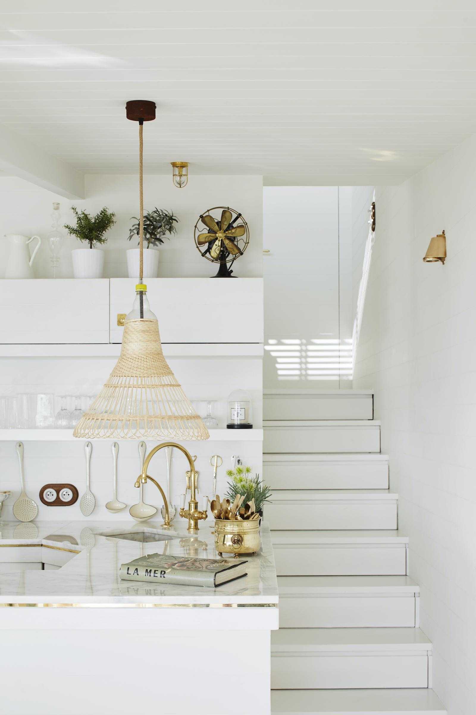 white coastal kitchen with steps and pendant light