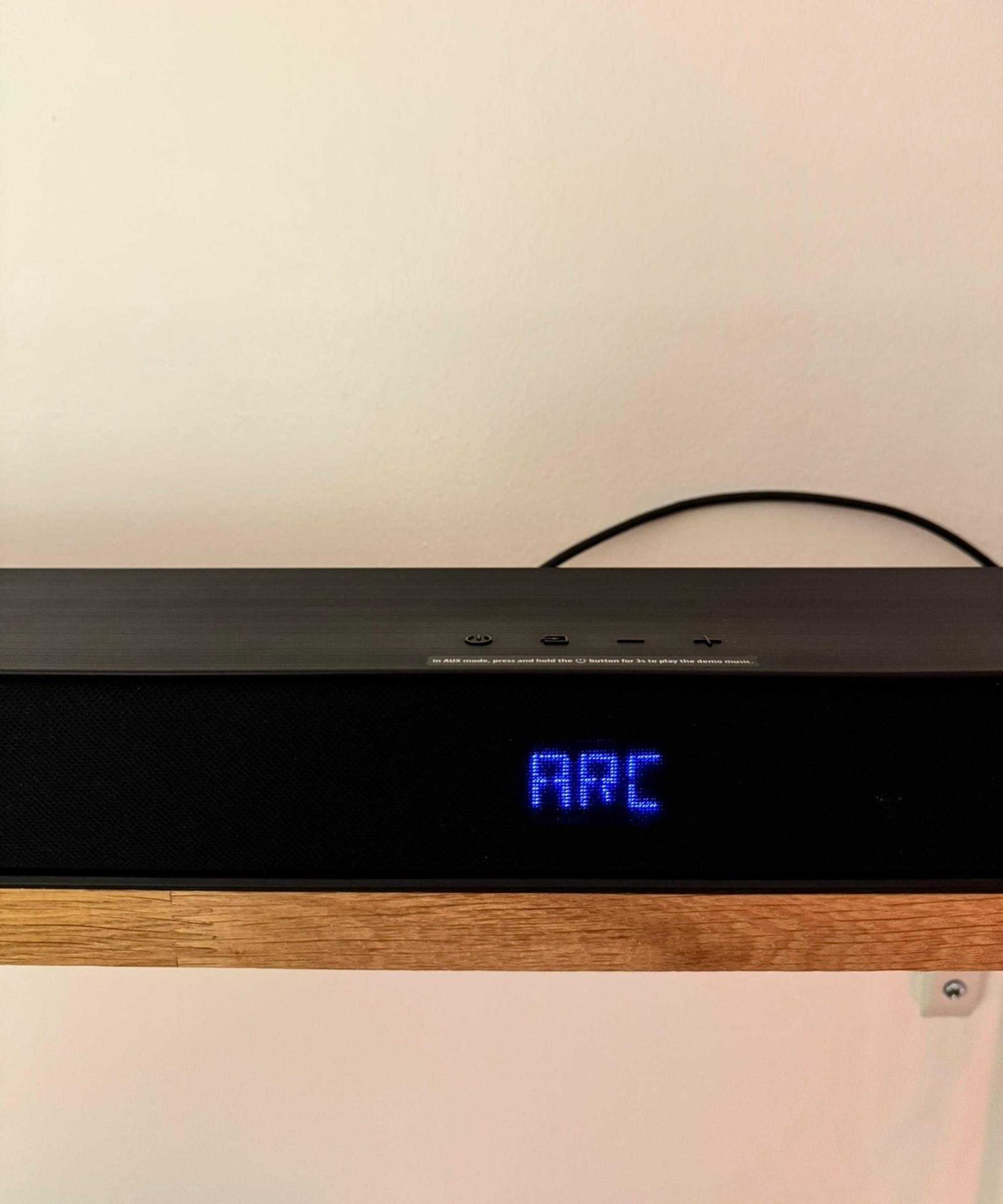 Hisense AX5140Q soundbar on wooden shelf, with blue lit-up text displaying 'ARC'.