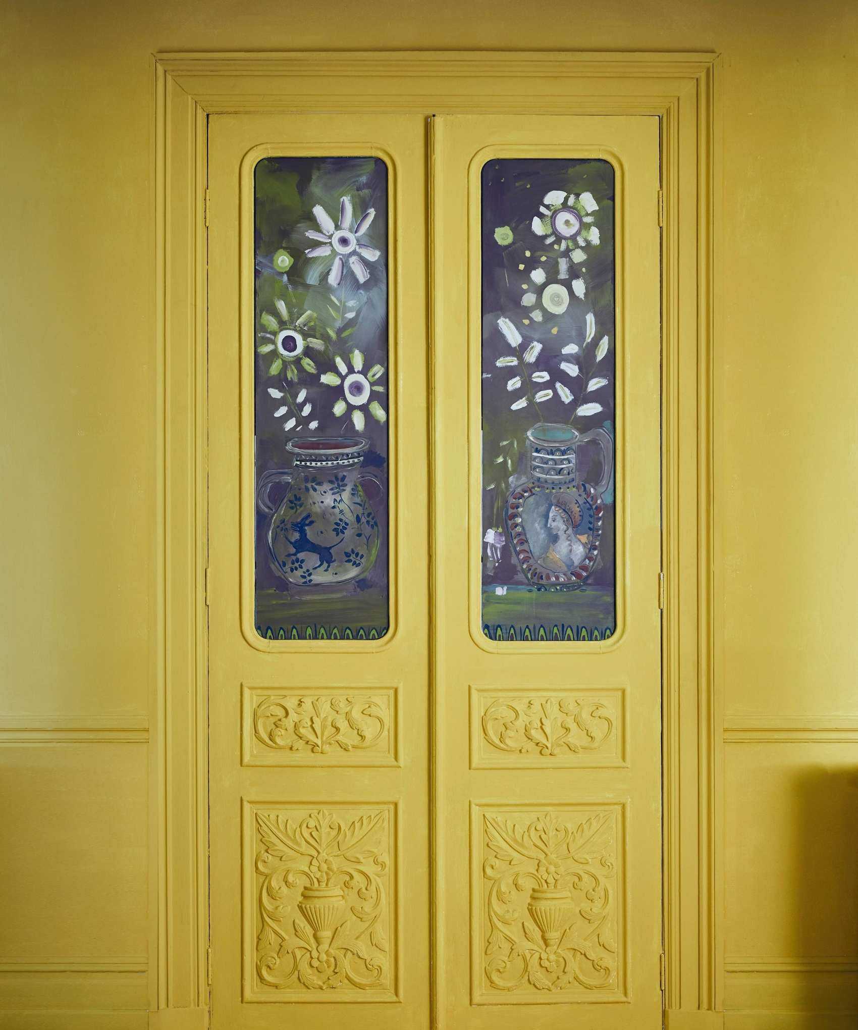 Yellow double doors with glass two glass panels, both of which have been handpainted