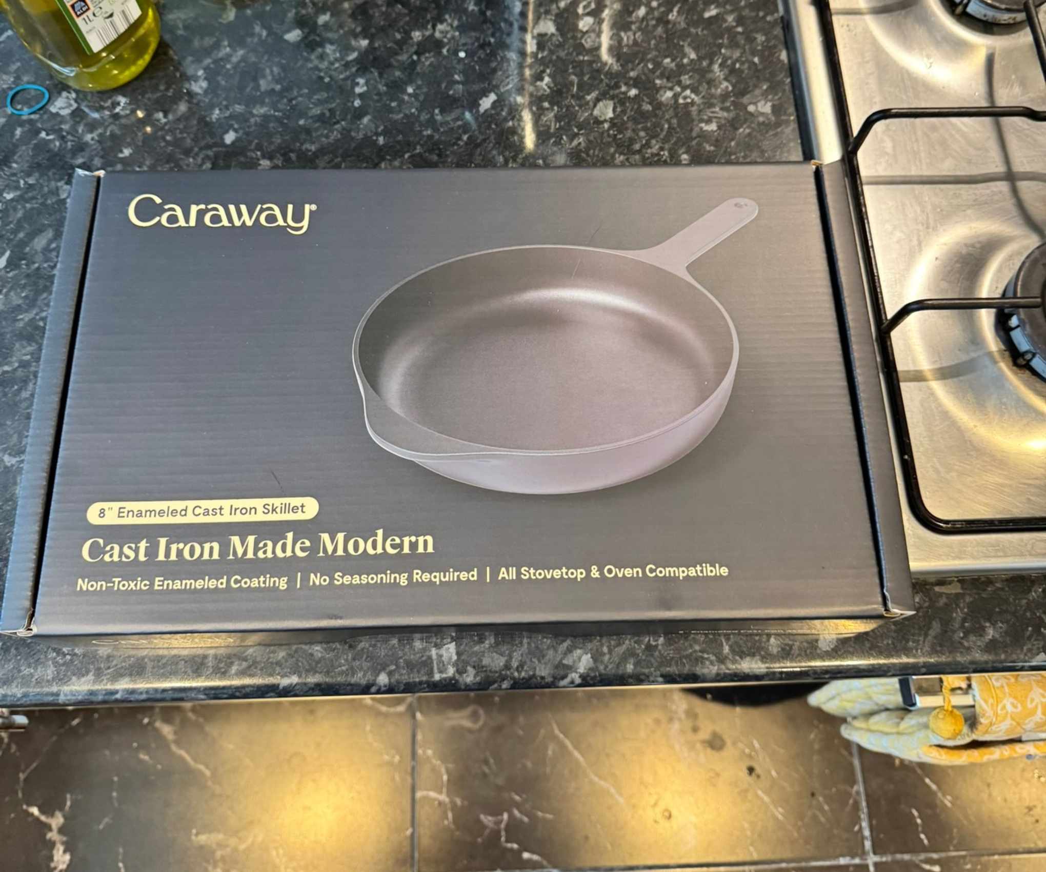 The Caraway black cast iron skillet box on a kitchen counter.
