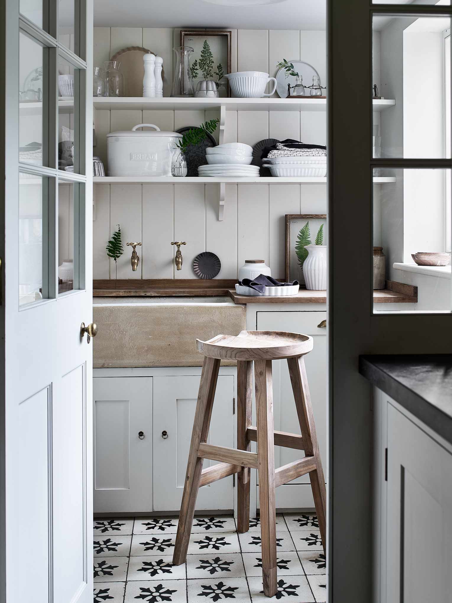 utility room with rustic stool and patterned floor tiles