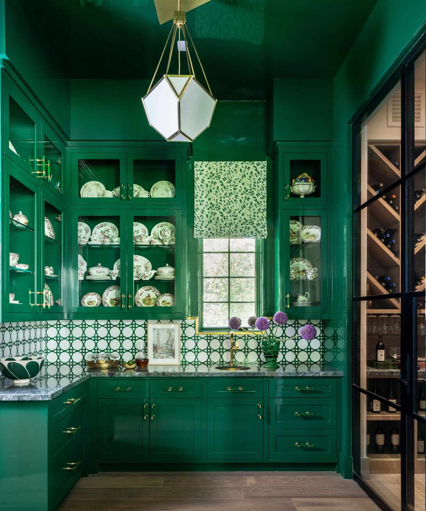 A butler's pantry color-drenched emerald green, including the cabinets and ceiling, in a high-gloss finish.