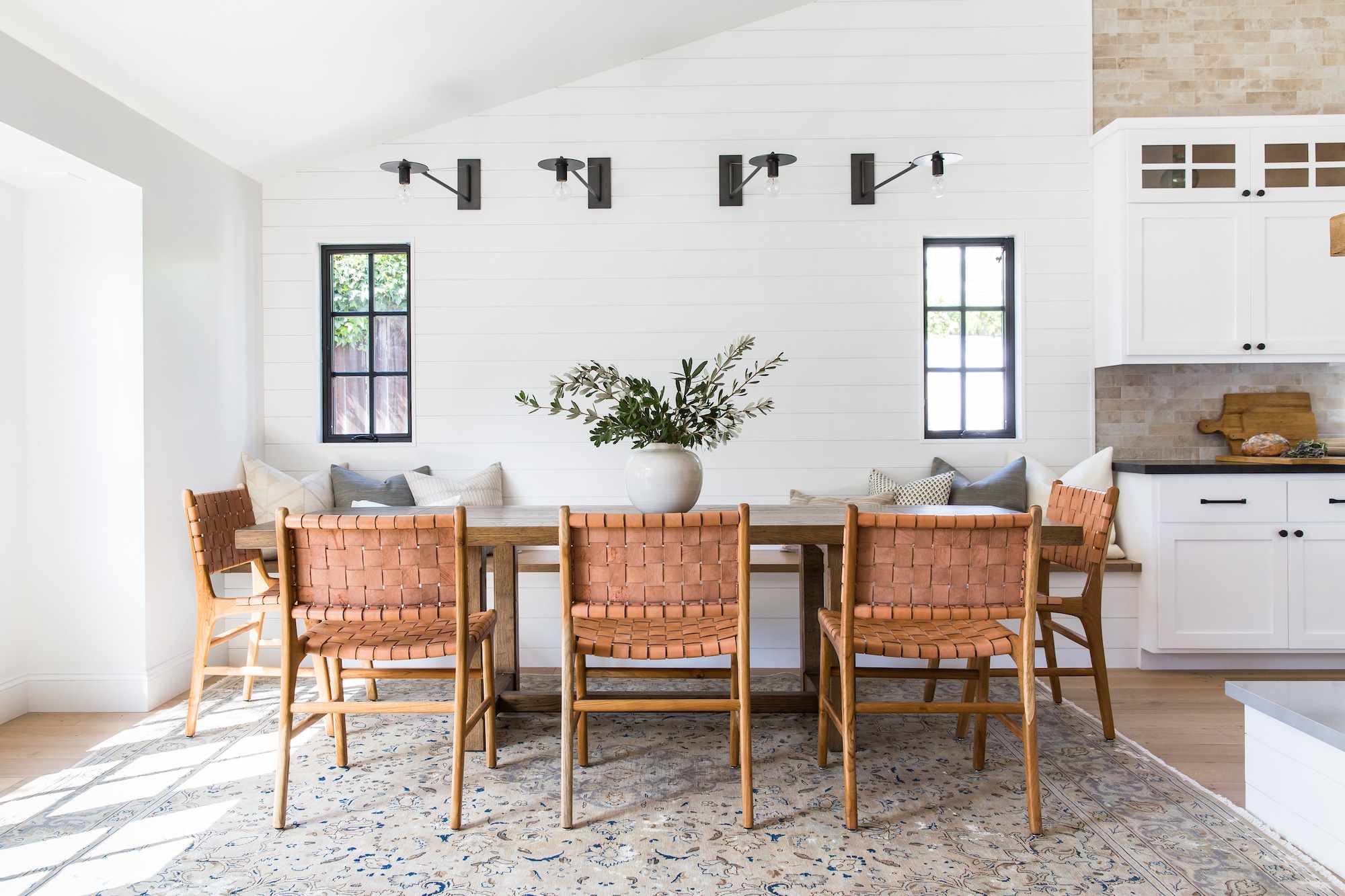modern farmhouse style kitchen with ribbed wooden pantry unit and black metal pendant lights