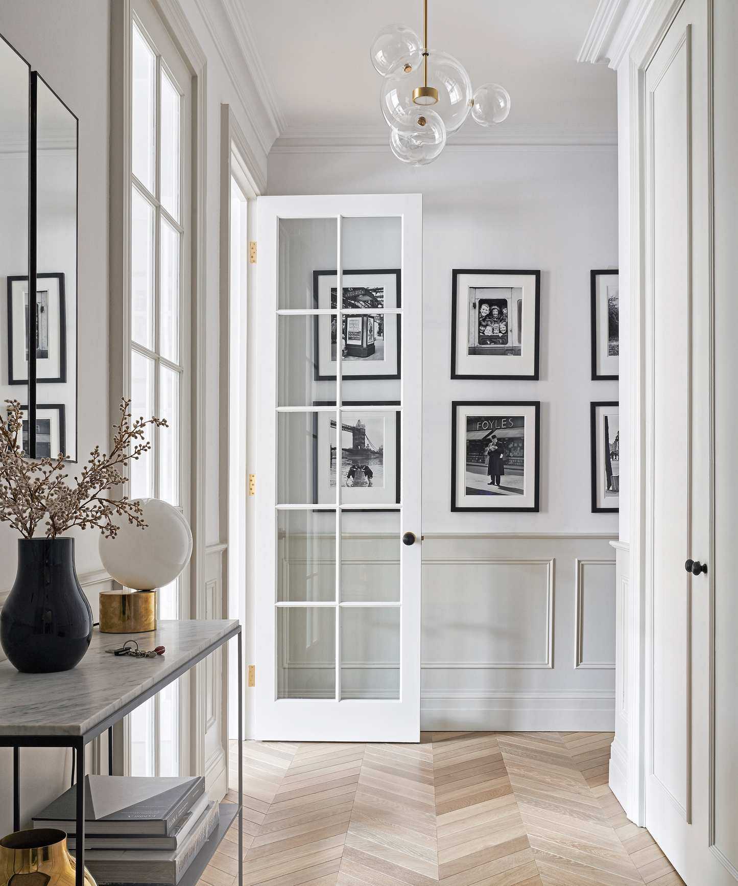 A modern hallway idea with French doors, contemporary orb chandelier and console table
