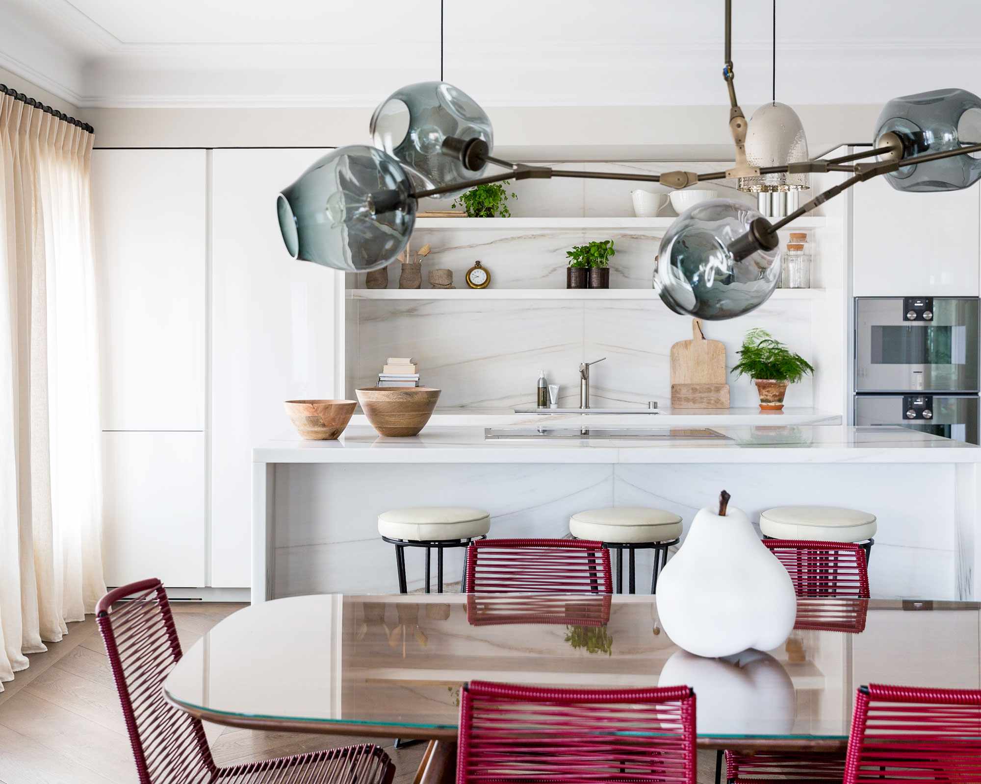 One wall kitchen with marble backsplash and red chairs