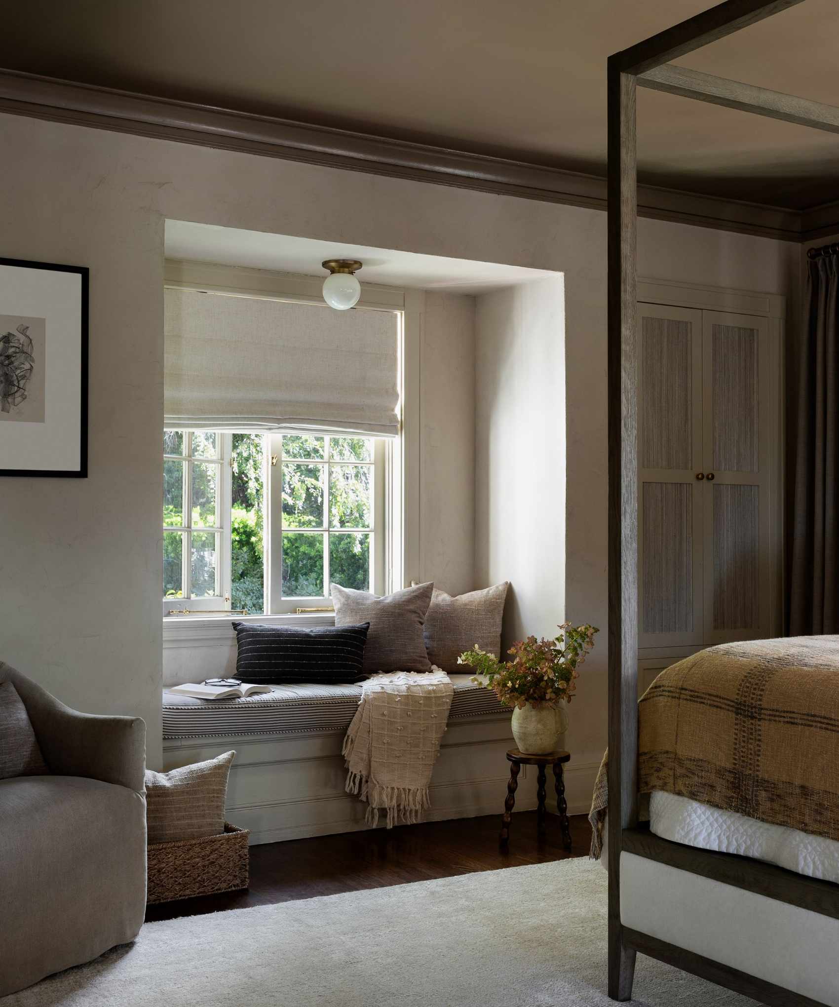 cozy bedroom with built in window seat for reading and a vintage four poster bed