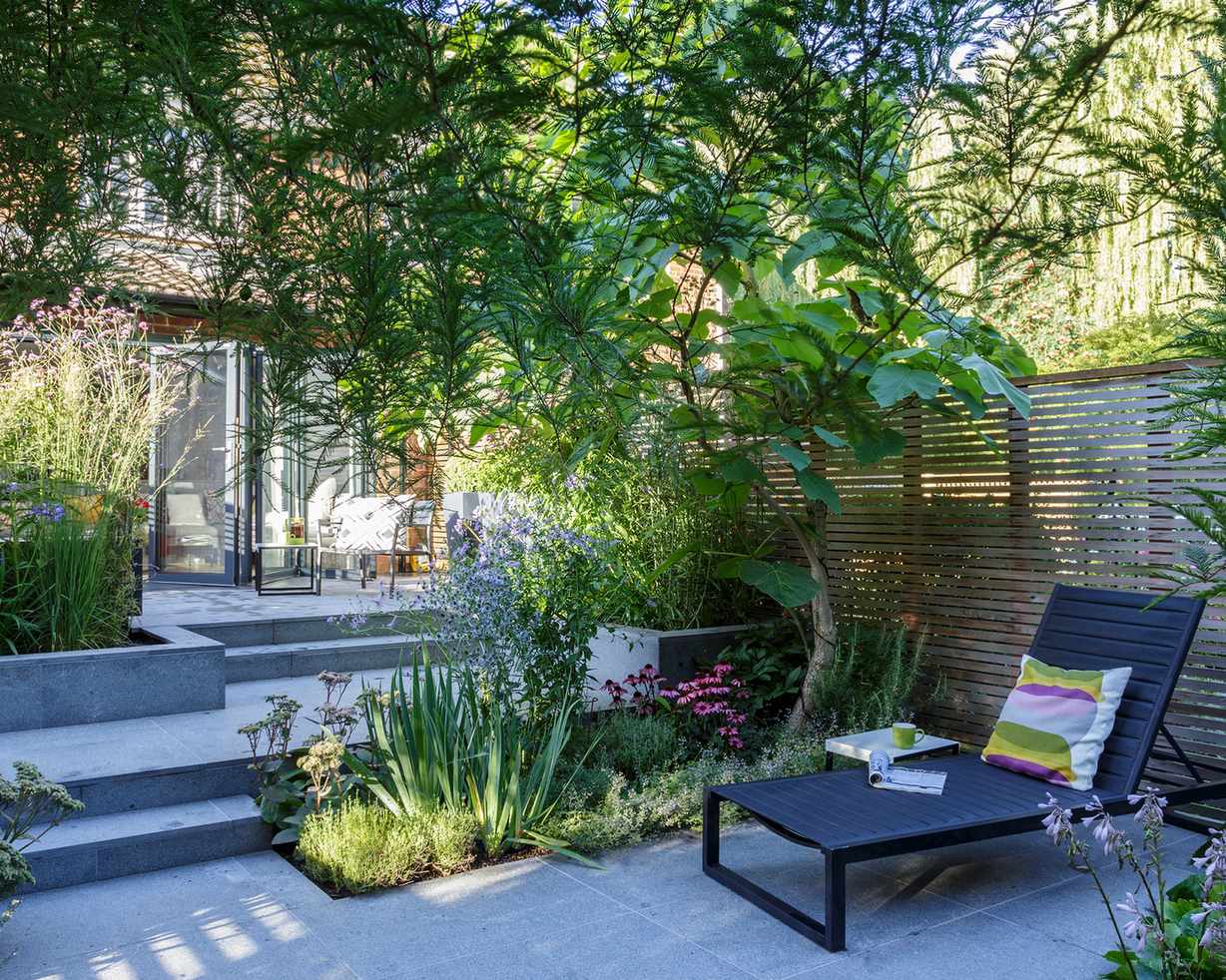 Garden with paved areas, planting and sun lounger
