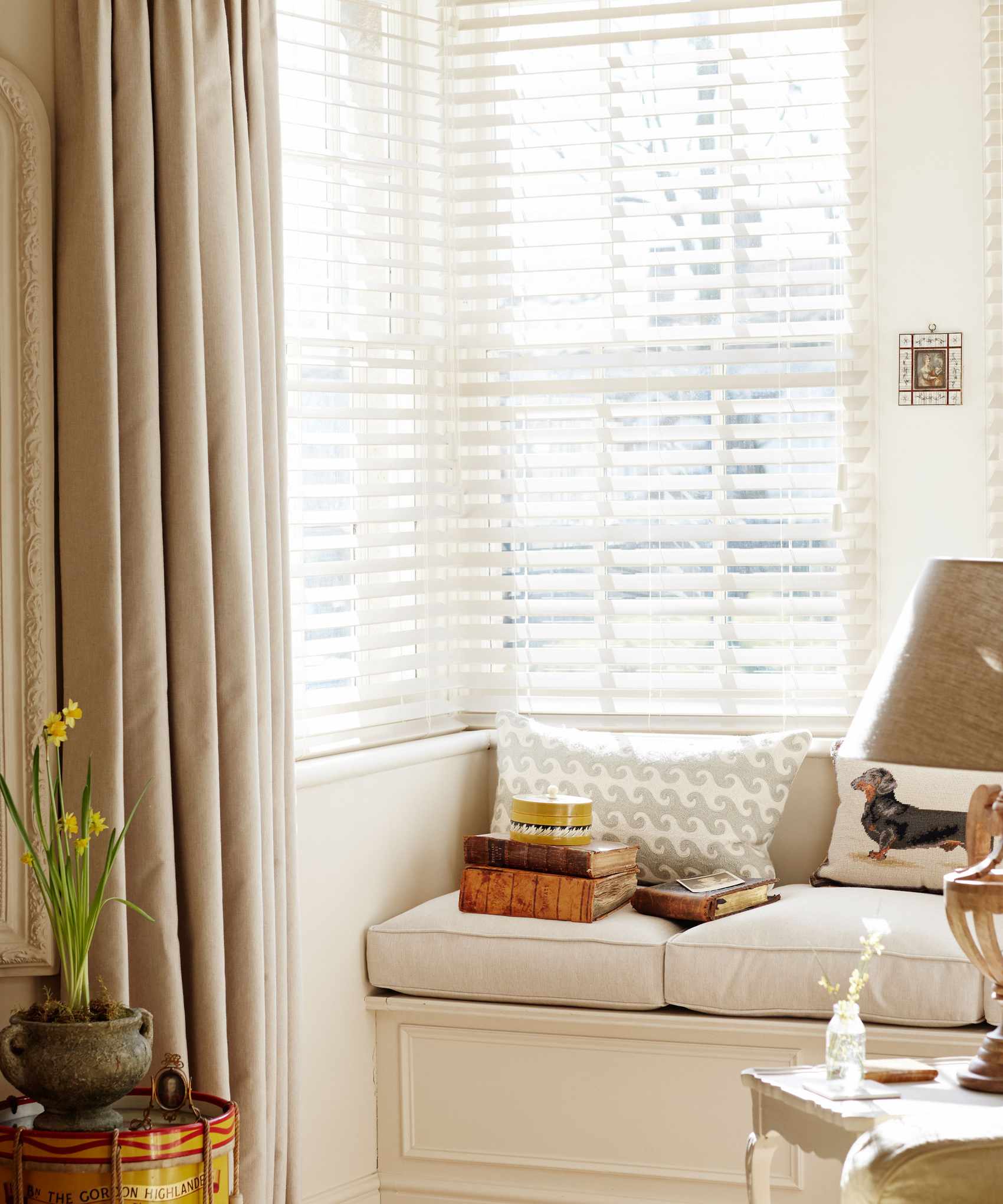 Corner window, windowseat with seat cushions, venetian blinds