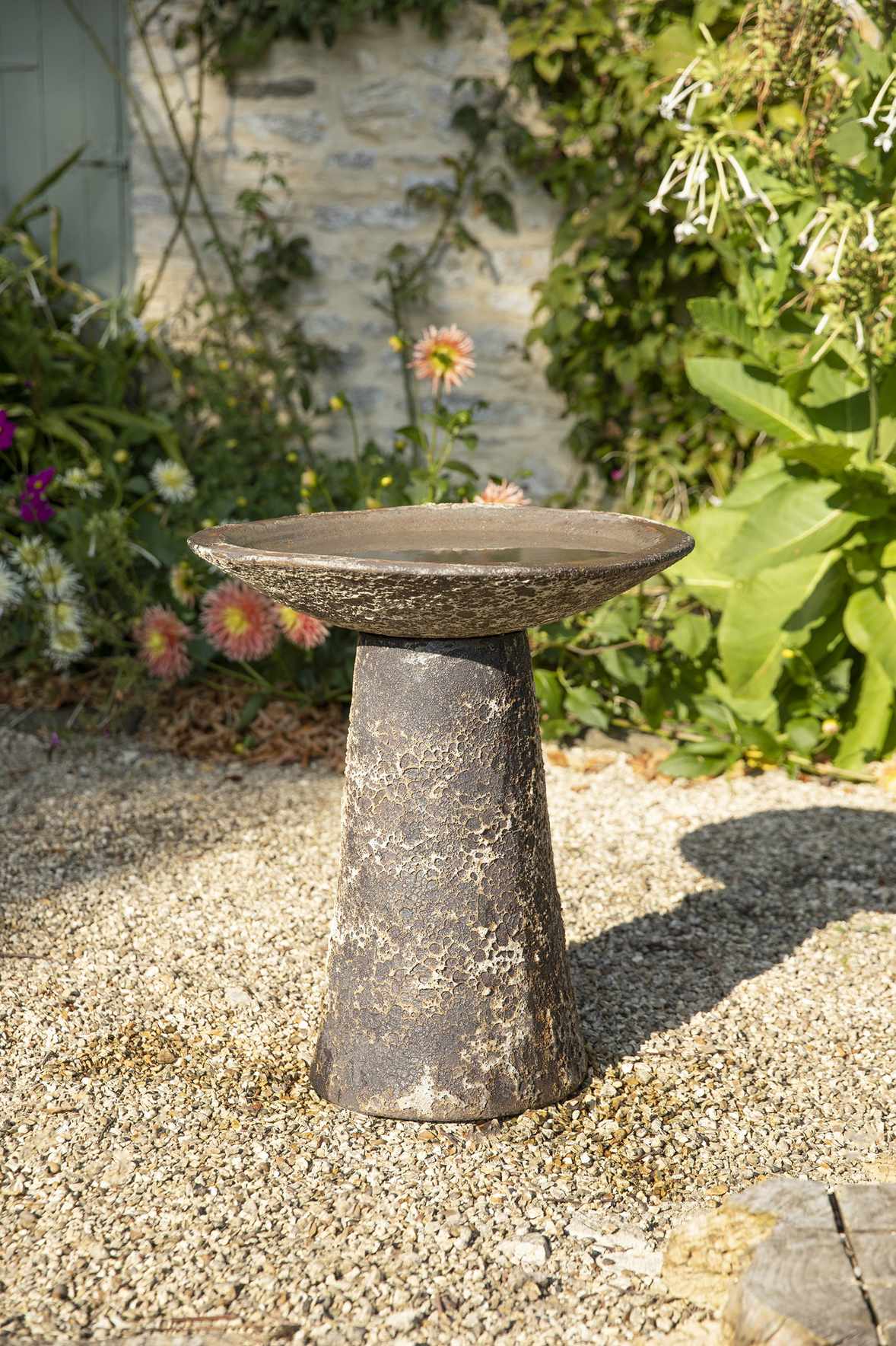 stone bird bath in a cottage garden