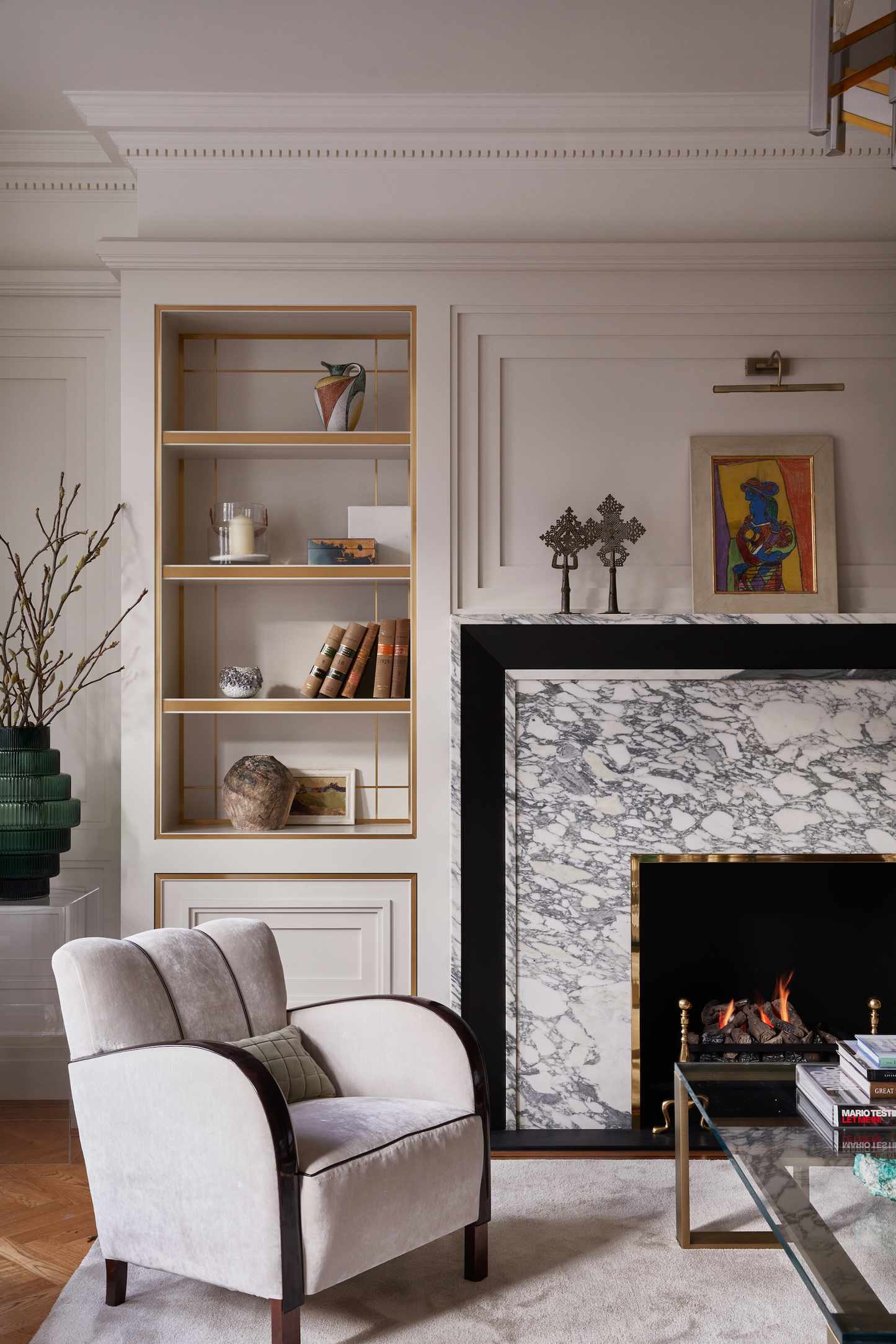 neutral living room with wooden floor, marble fireplace, armchair, alcove