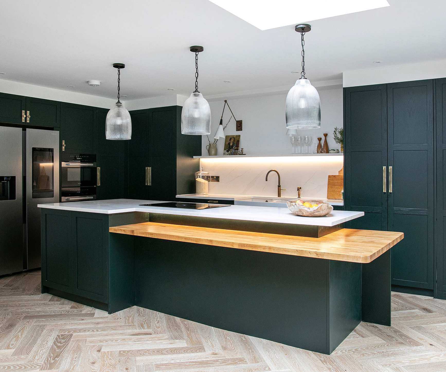 Three glass kitchen pendant lights hung above a kitchen island