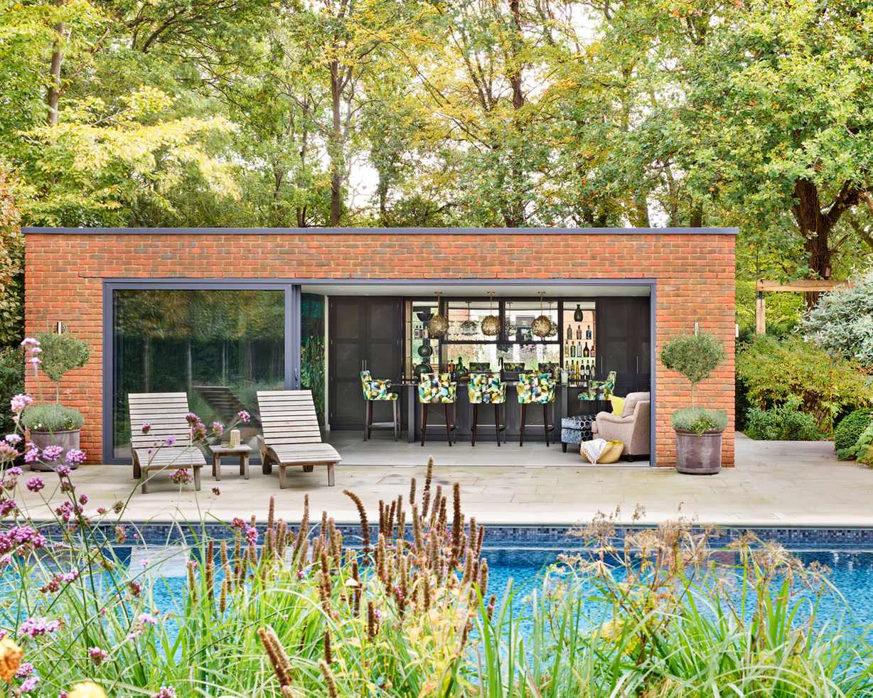 Pool house ideas with deck chairs and kitchen area
