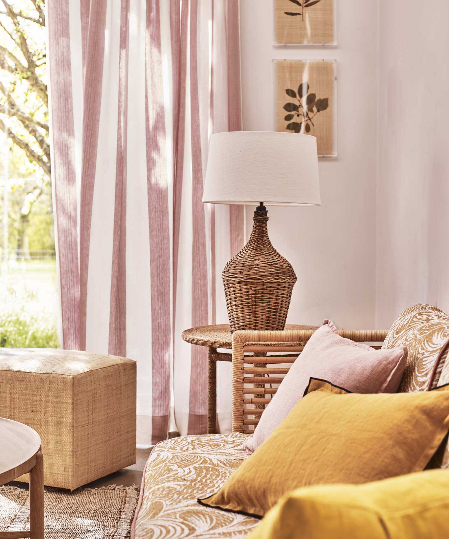 A living room curtain idea with pink and white striped fabric and yellow and rattan accessories