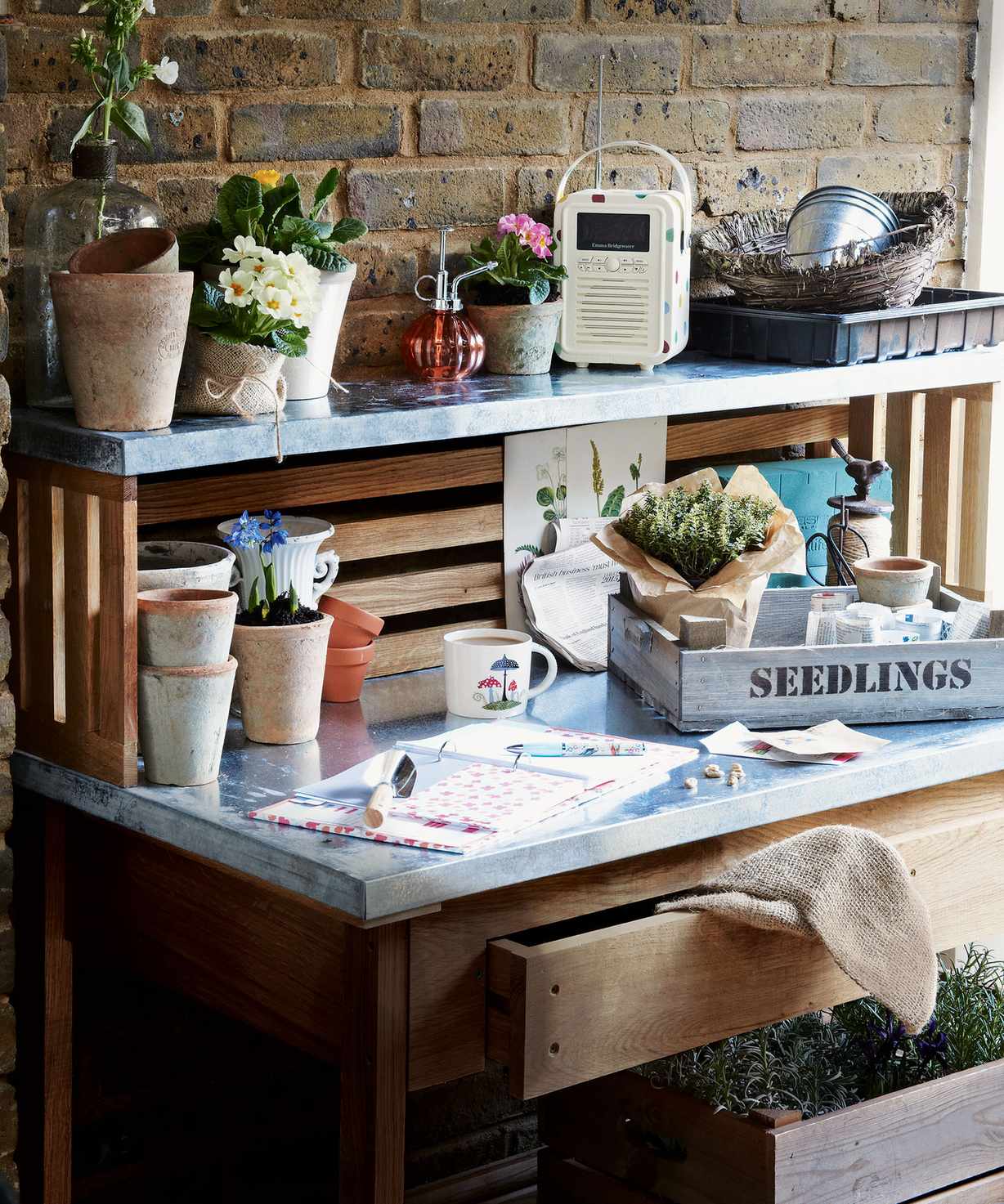A wood work bench with metal countertop and shelf, used for planting seedlings in storage ideas for sheds.