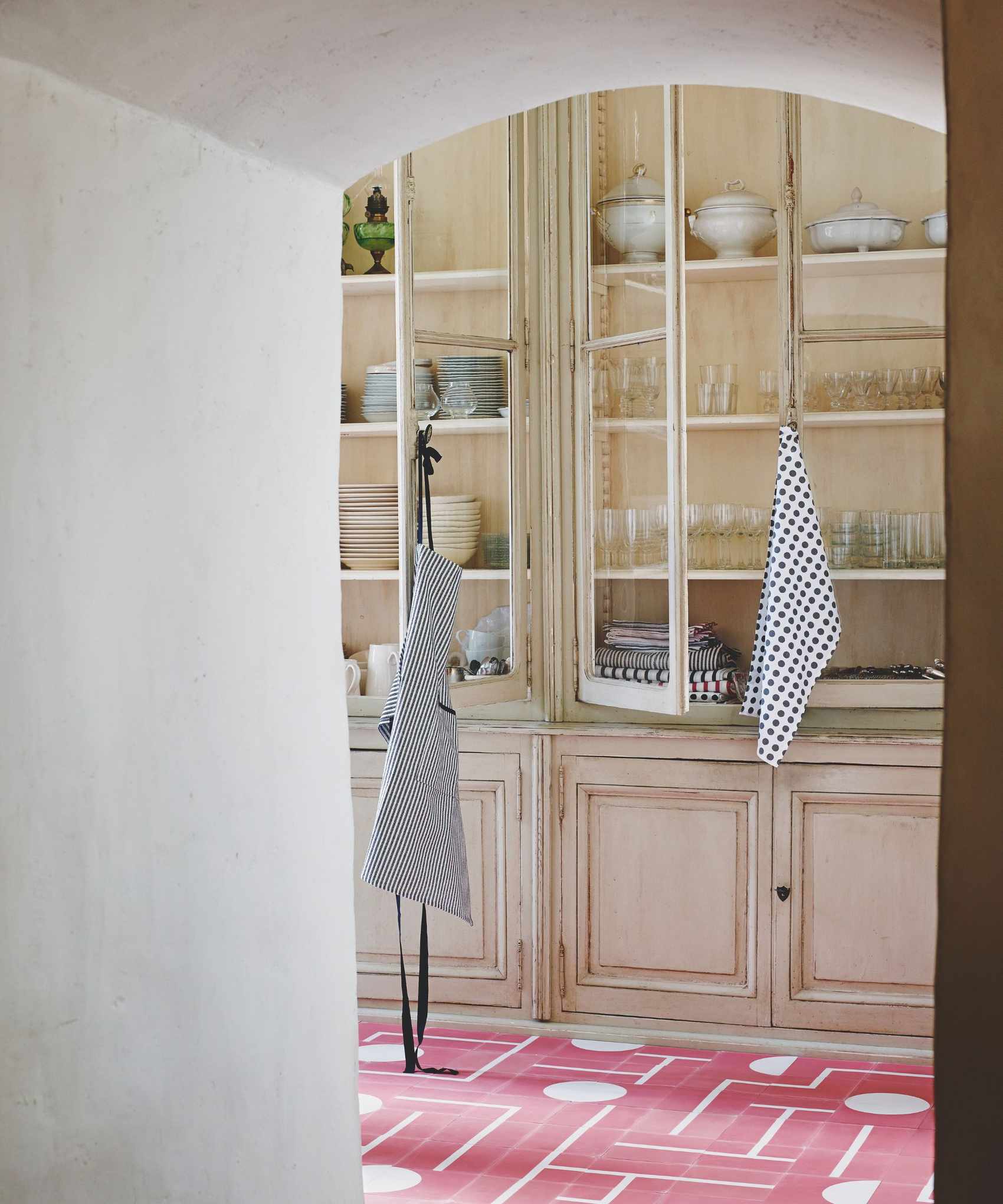 Cabinet with glassware and crockery through an arched doorway