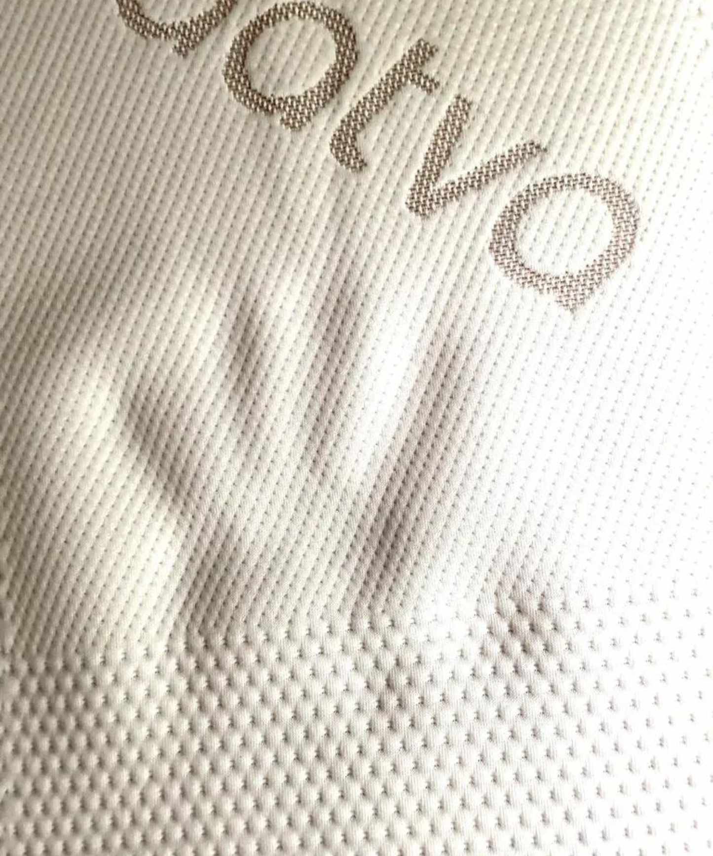 A handprint shown in the Saatva Graphite Mattress Topper, to show the firmness of the topper.