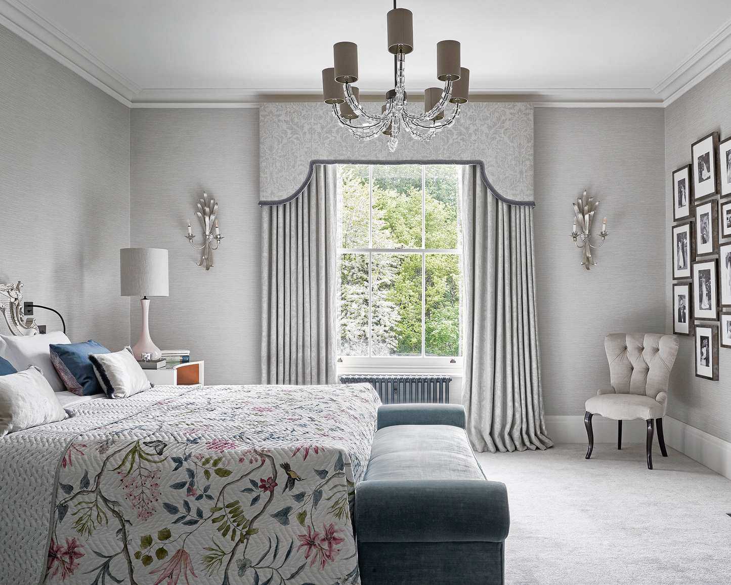 Bedroom with a double bed, fireplace, sash window, pelmet and curtains, and floral pattern quilt.