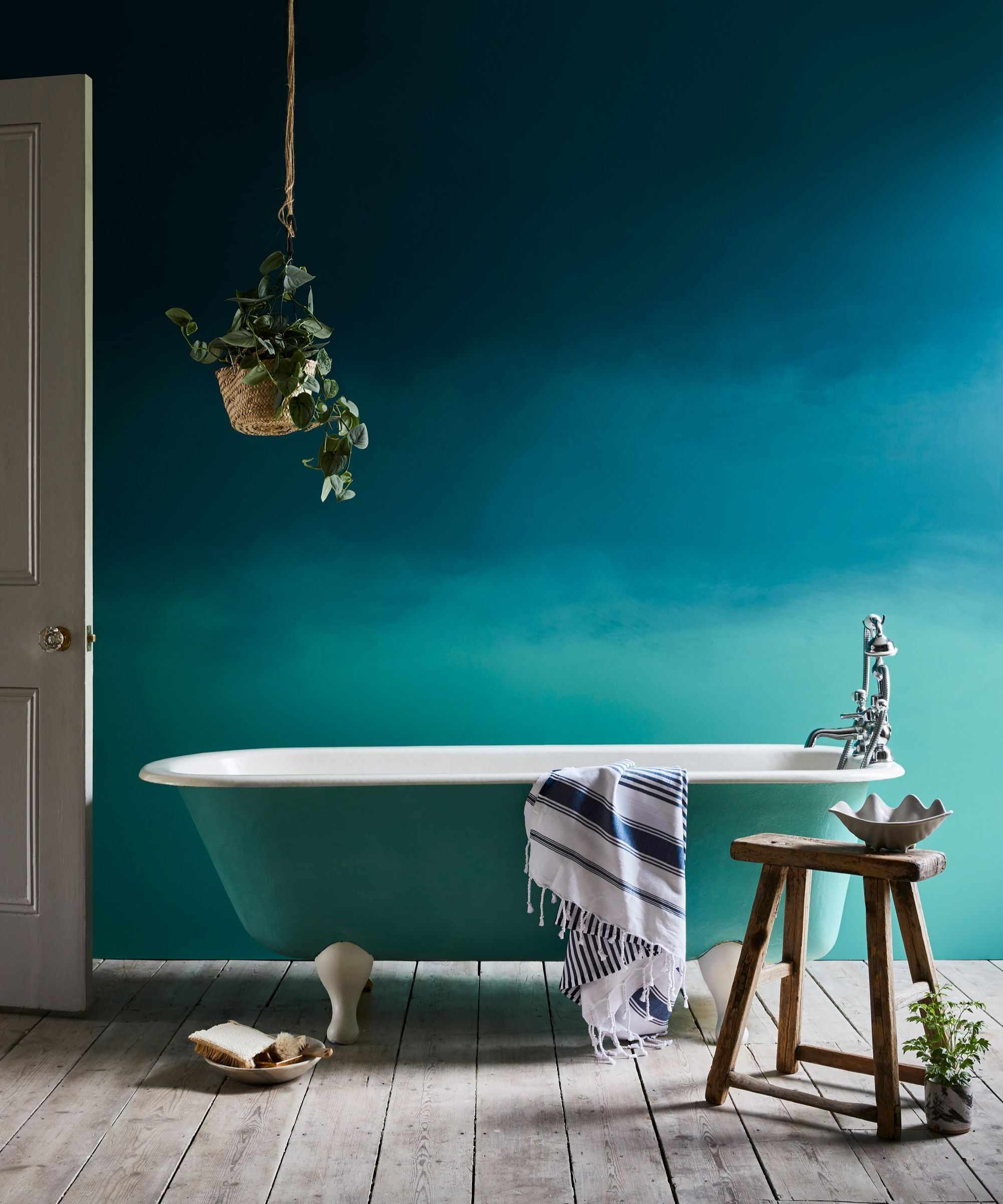 A bathroom with a wall painted blue in an ombre effect