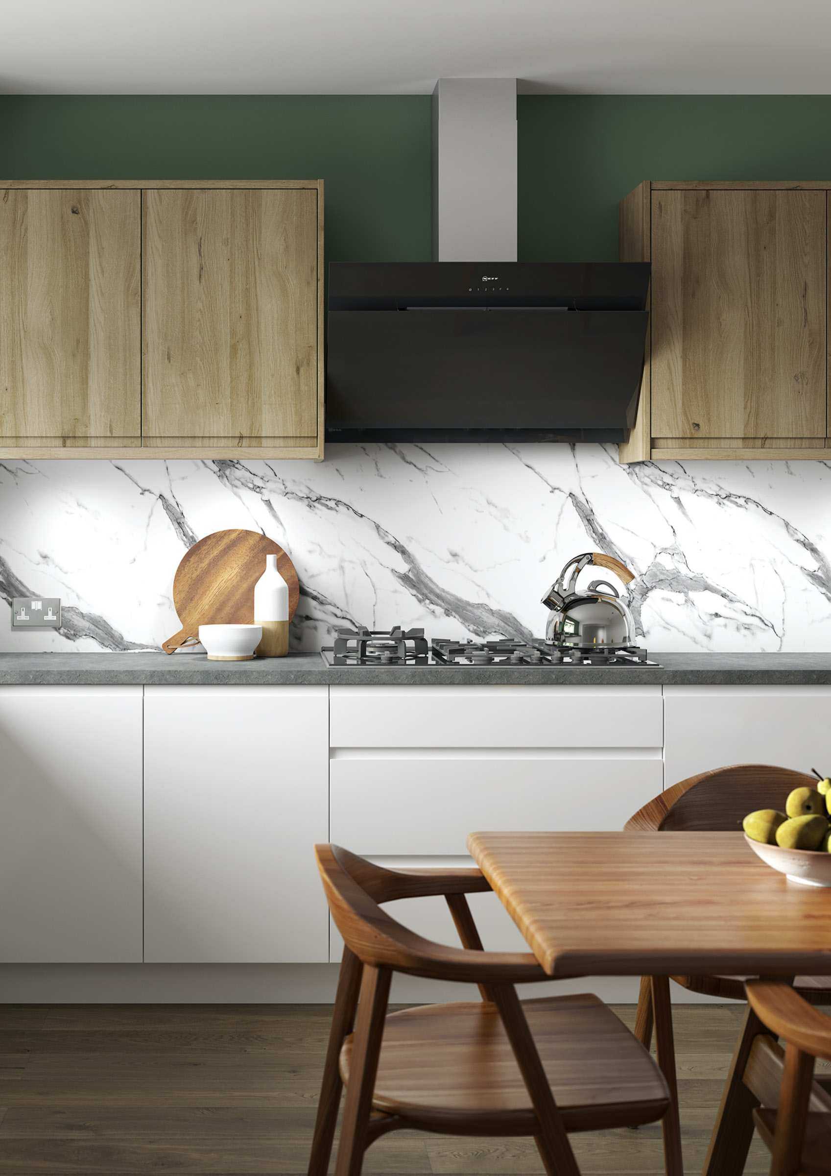 Green kitchen with marble splashback and light wooden cupboards, dark wooden flooring and dining table