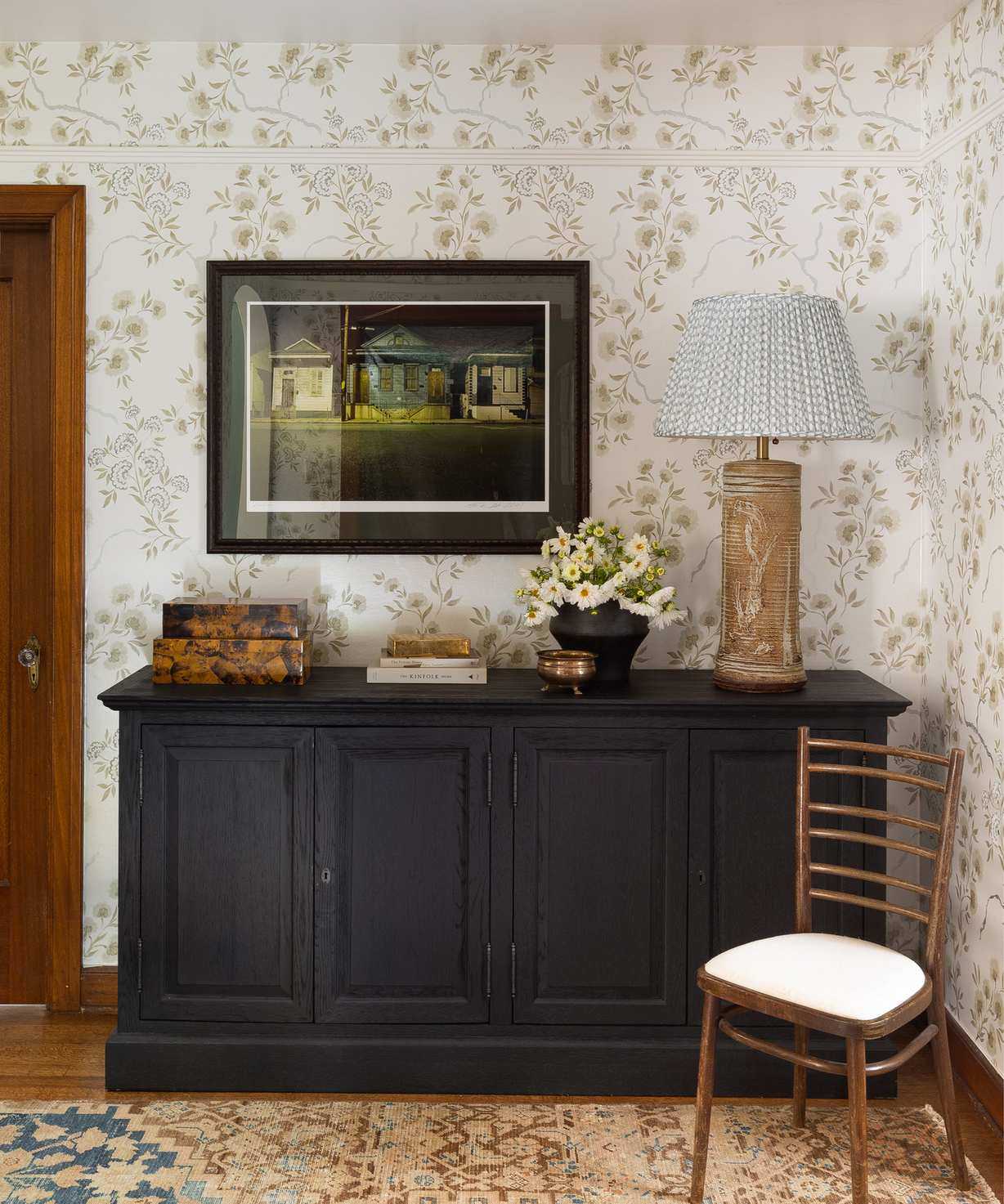 Rustic hallway in 1920s Tudor revival house in Seattle, table decorated with table lamp, artwork, flowers, books