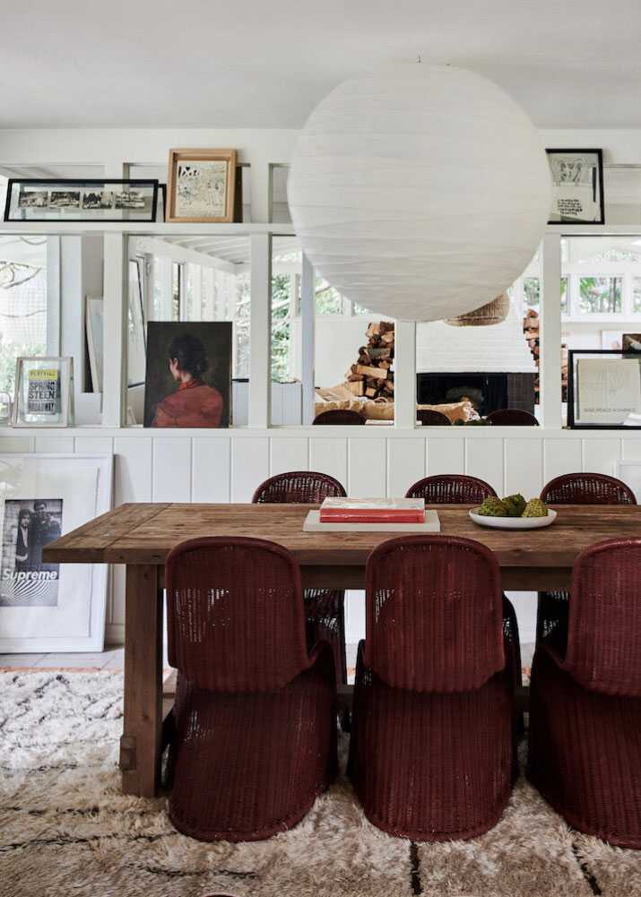 Farmhouse decor ideas, modern dining room with wooden dining table, wicker chairs, artwork gallery wall