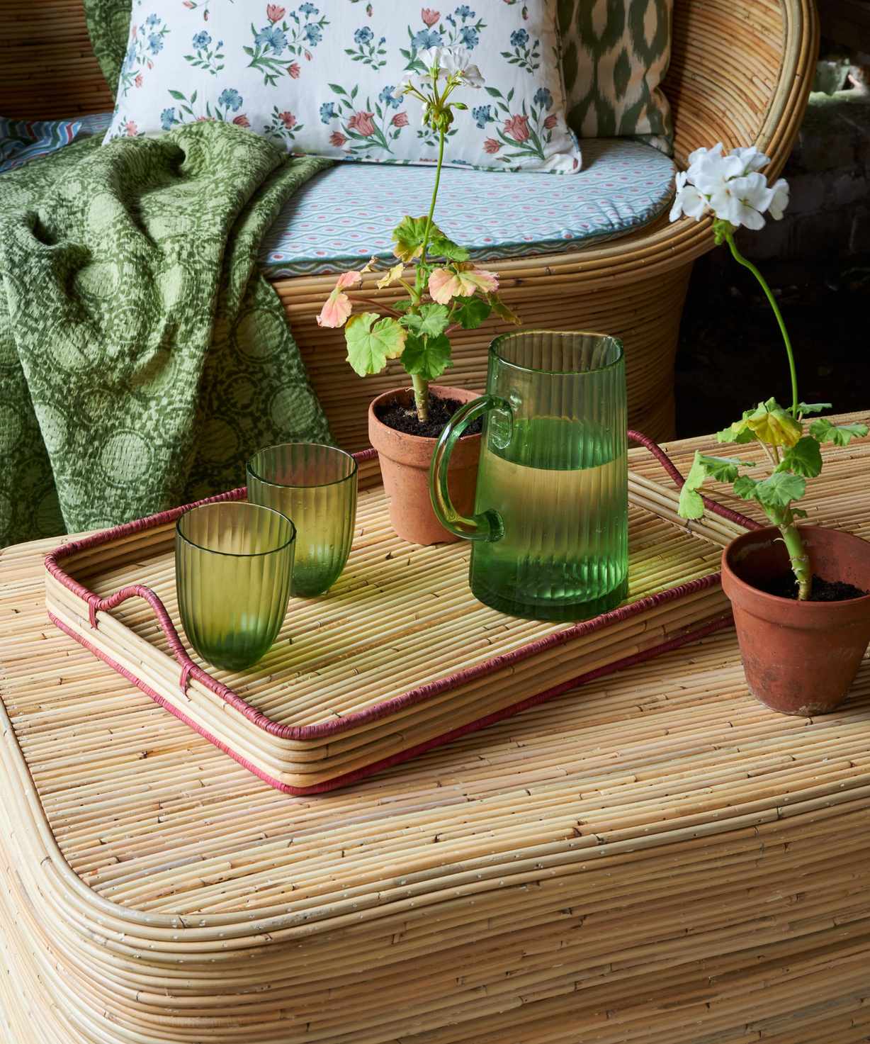 Green glassware on rattan coffee table