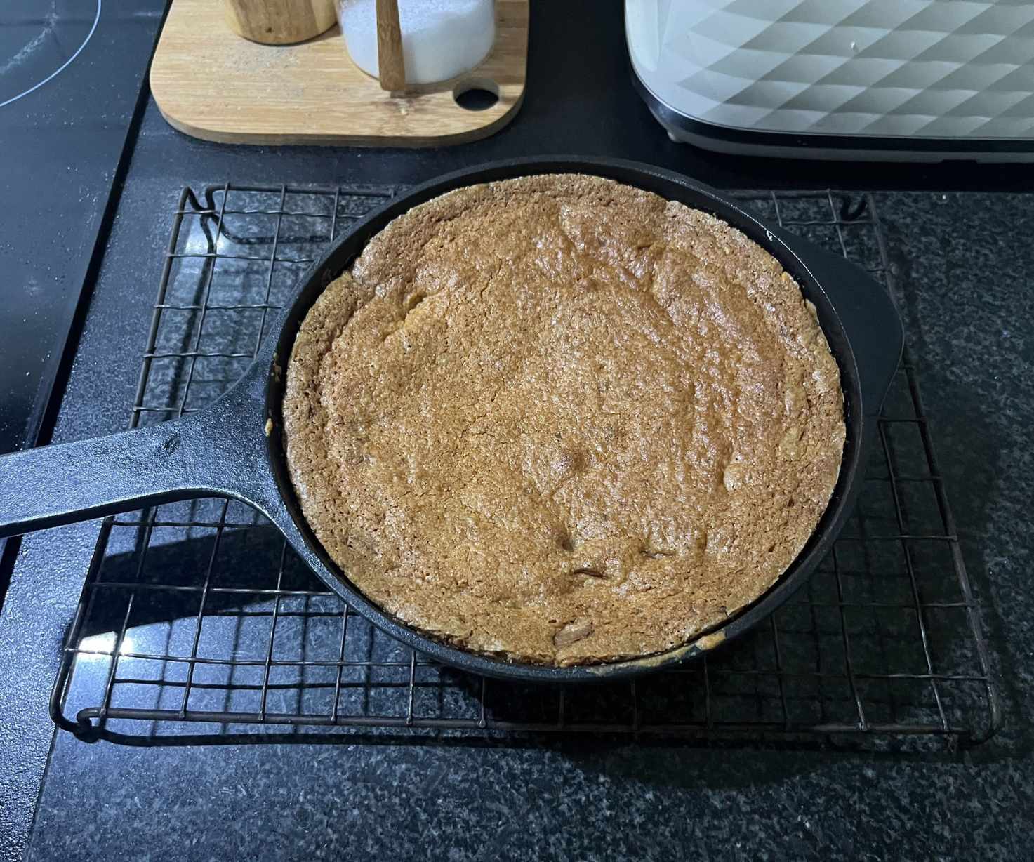 A golden baked cookie in a black cast iron skillet.