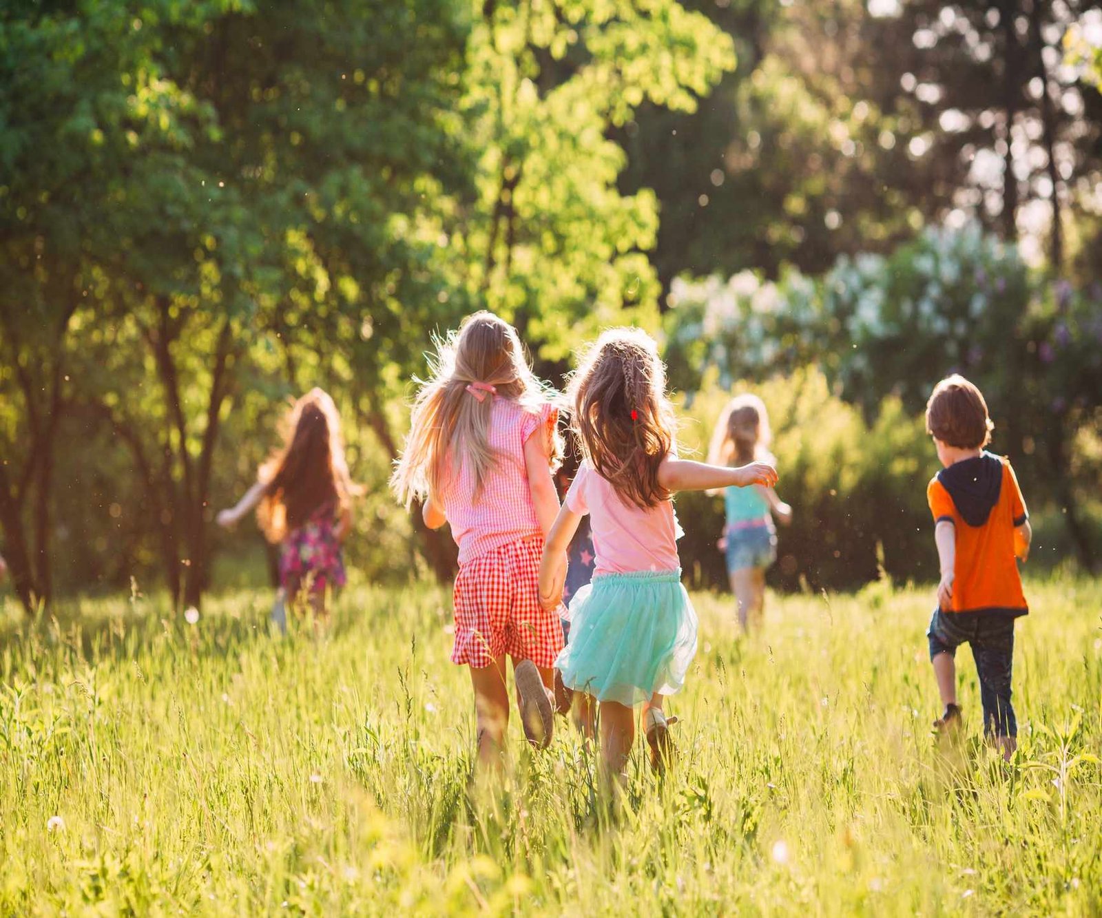 Children playing outside in a sunny field