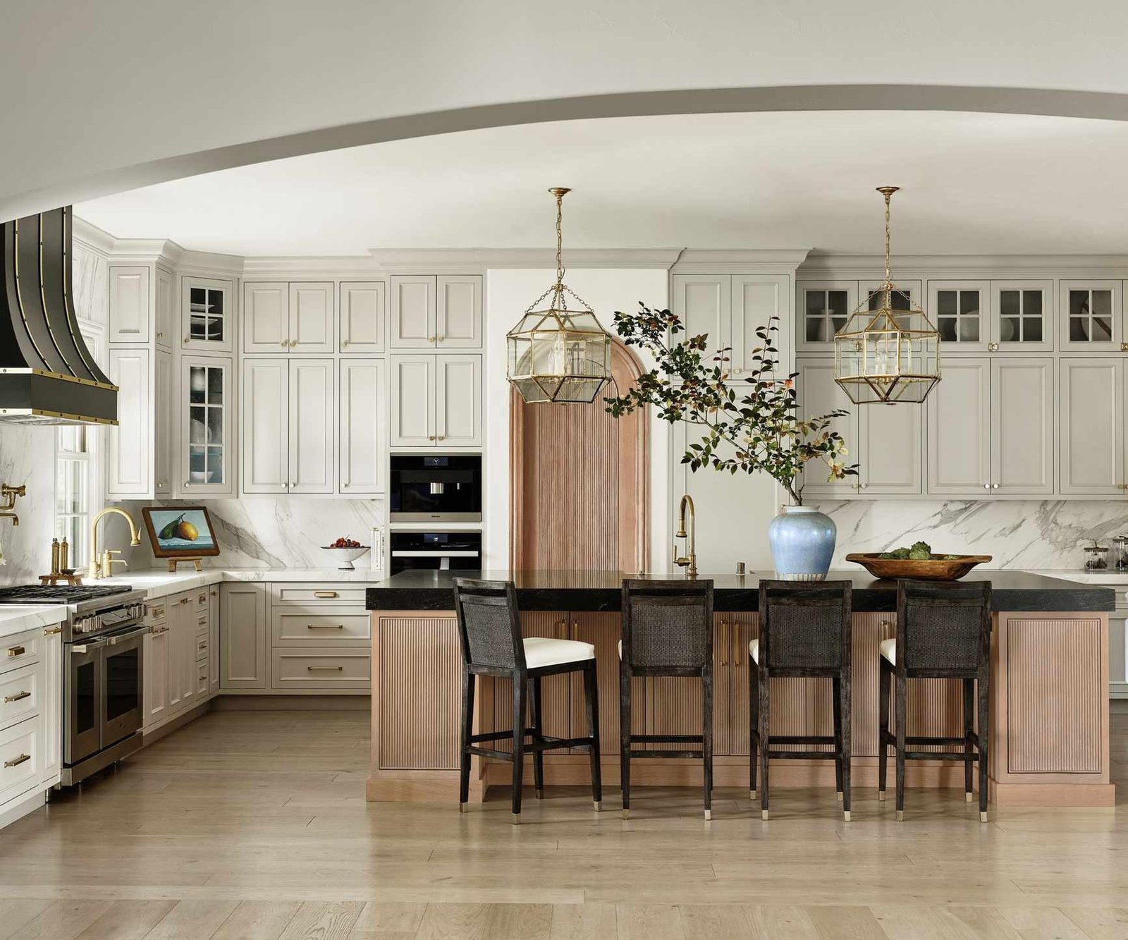 kitchen with cream units and black cooker hood with wood island detail